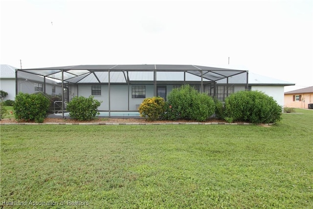 back of property featuring a yard and glass enclosure