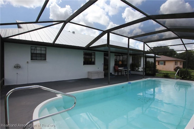 view of swimming pool with a patio area and a lanai