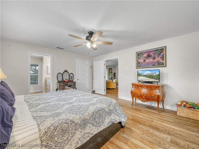 bedroom with visible vents, ceiling fan, baseboards, and wood finished floors