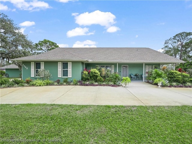 ranch-style house featuring a front yard, covered porch, and stucco siding