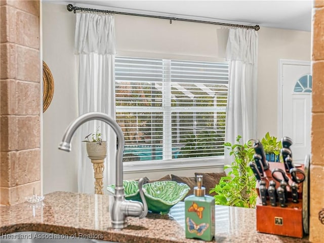 interior details featuring stone countertops and a sink