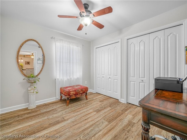 living area with light wood-type flooring, ceiling fan, and baseboards