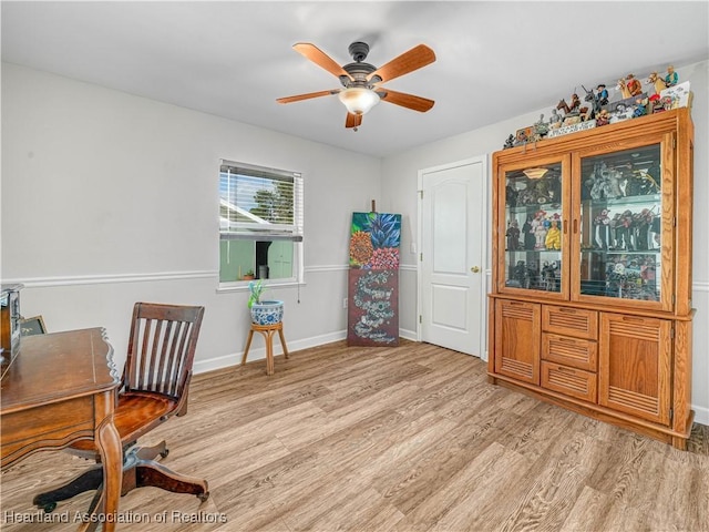 office with light wood-type flooring, baseboards, and a ceiling fan