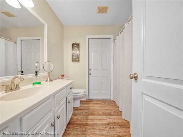 full bathroom featuring visible vents, vanity, toilet, and wood finished floors