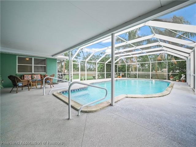 pool with glass enclosure, a patio, and an outdoor hangout area