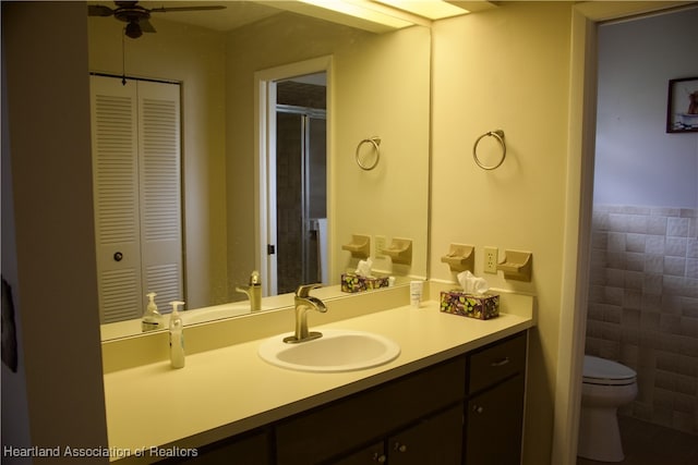102 Oak St, Lake Placid, FL 33852 - full bathroom featuring tile walls, a closet, toilet, a ceiling fan, and vanity