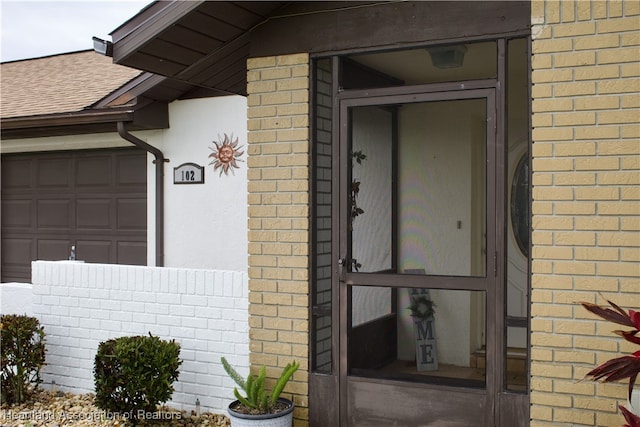 102 Oak St, Lake Placid, FL 33852 - entrance to property with brick siding, a shingled roof, and an attached garage