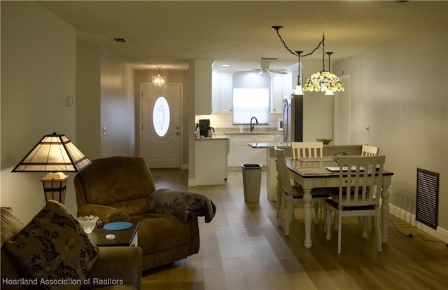 102 Oak St, Lake Placid, FL 33852 - dining space with a ceiling fan, light wood-style floors, and baseboards