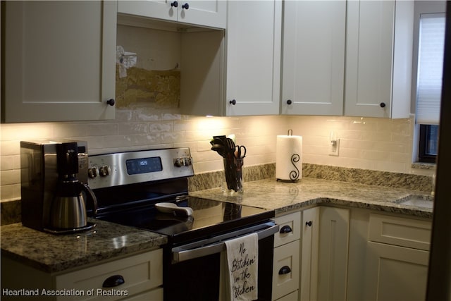 102 Oak St, Lake Placid, FL 33852 - kitchen with stainless steel range with electric stovetop, backsplash, white cabinetry, and light stone counters