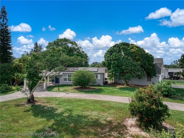301 Sparrow Ave, Sebring, FL 33870 - view of front of home with solar panels, a front yard, and stucco siding