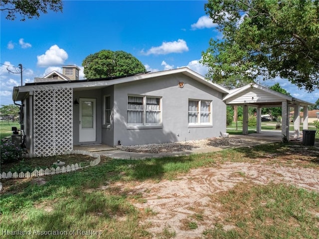 301 Sparrow Ave, Sebring, FL 33870 - view of front facade with stucco siding, a chimney, and a carport