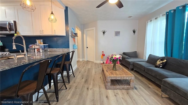 301 Sparrow Ave, Sebring, FL 33870 - living area with ceiling fan and light wood finished floors