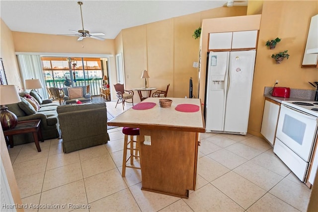 4869 Casablanca Cir Unit G22, Sebring, FL 33870 - kitchen featuring white appliances, a breakfast bar area, light tile patterned floors, a ceiling fan, and open floor plan