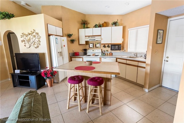 4869 Casablanca Cir Unit G22, Sebring, FL 33870 - kitchen with white appliances, under cabinet range hood, light countertops, a center island, and a breakfast bar