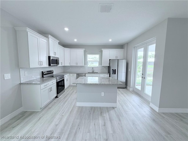 kitchen with appliances with stainless steel finishes, a sink, healthy amount of natural light, backsplash, and recessed lighting