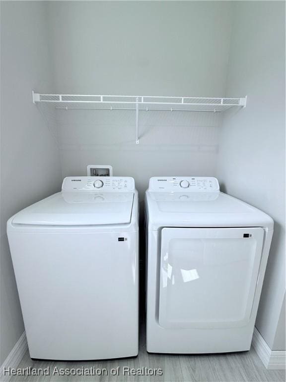 clothes washing area featuring baseboards and washing machine and clothes dryer