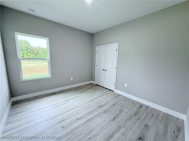 unfurnished room featuring light wood-style flooring and baseboards