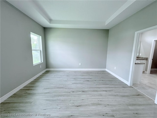 empty room with a raised ceiling and baseboards
