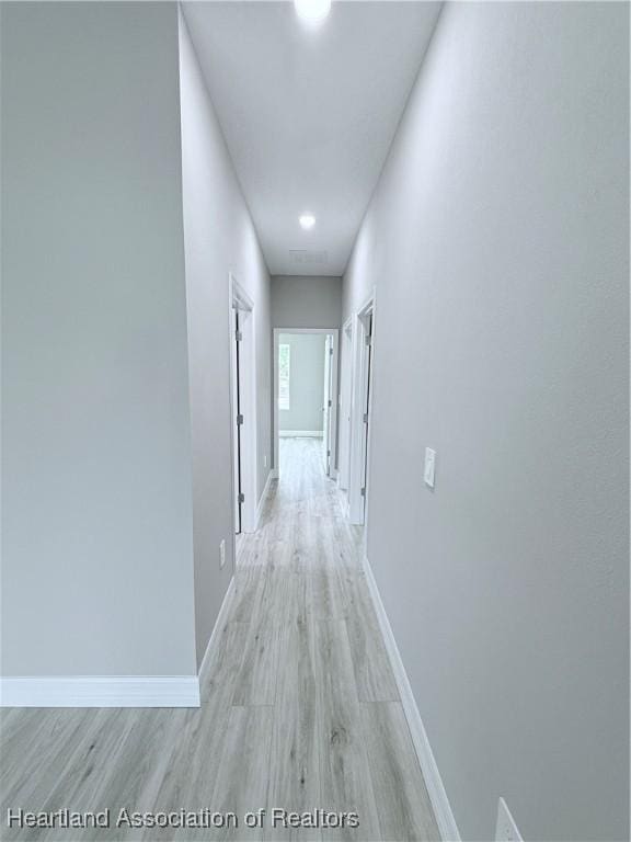 hall with light wood finished floors and baseboards