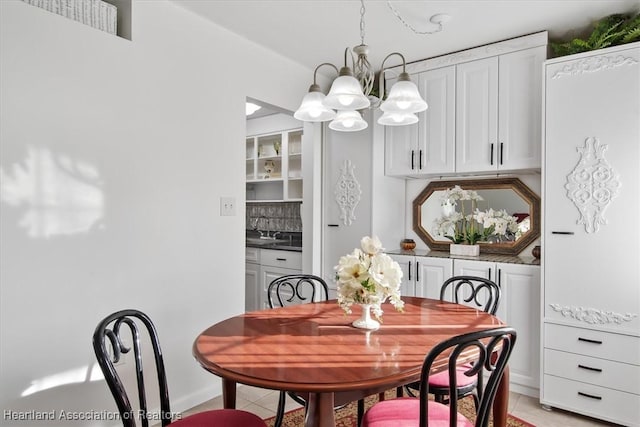 tiled dining space featuring a chandelier and sink