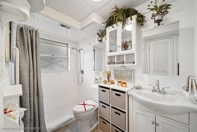 bathroom with a shower with curtain, tile patterned flooring, toilet, a paneled ceiling, and vanity