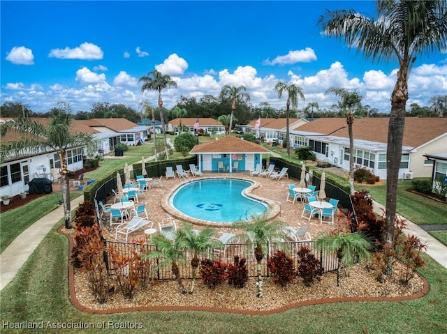 view of swimming pool featuring a yard, an outdoor structure, and a patio