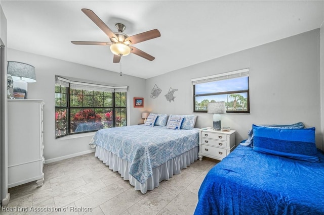 bedroom with ceiling fan and multiple windows