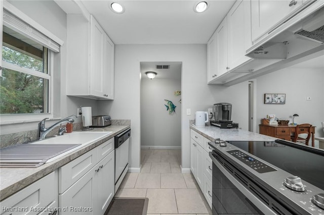 kitchen with light tile patterned floors, stainless steel appliances, and white cabinets