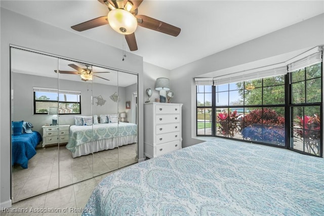 tiled bedroom with ceiling fan and a closet