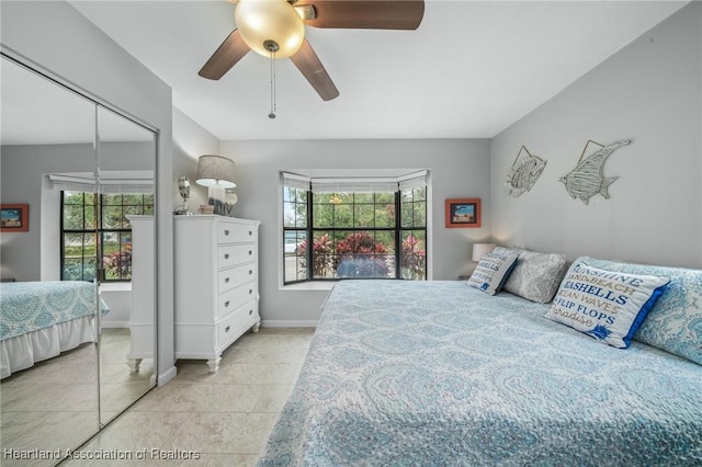 bedroom featuring multiple windows, tile patterned flooring, and ceiling fan