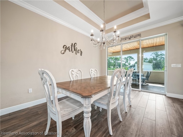 dining space featuring crown molding, dark hardwood / wood-style flooring, a chandelier, and a raised ceiling