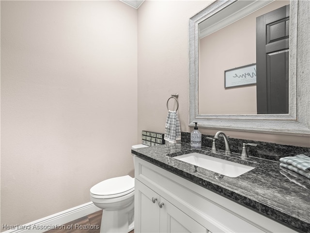 bathroom featuring vanity, crown molding, wood-type flooring, and toilet