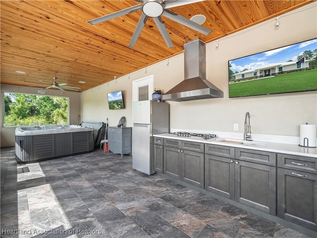 view of patio / terrace with a hot tub, exterior kitchen, sink, and ceiling fan