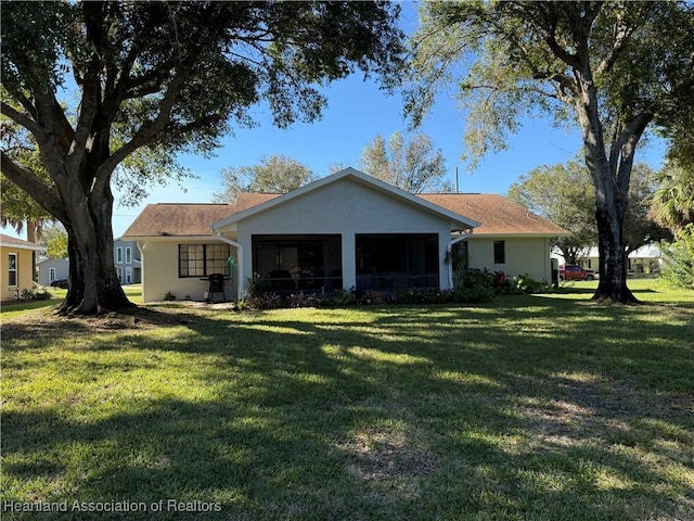 ranch-style home with a sunroom and a front lawn