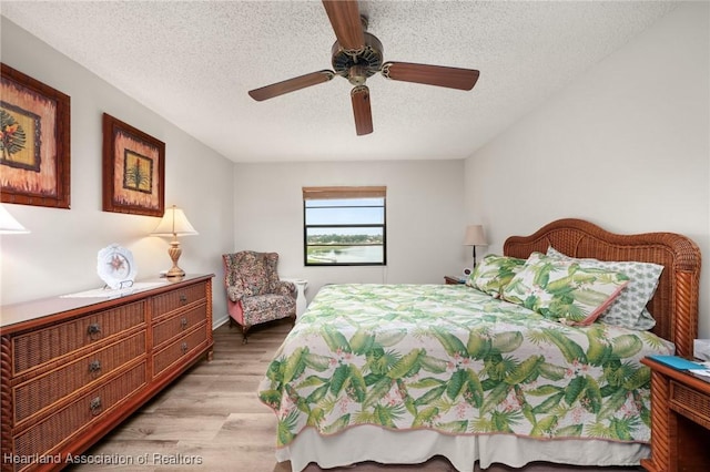 19 A Miracle Ave, Avon Park, FL 33825 - bedroom featuring light wood-style floors, a textured ceiling, and a ceiling fan