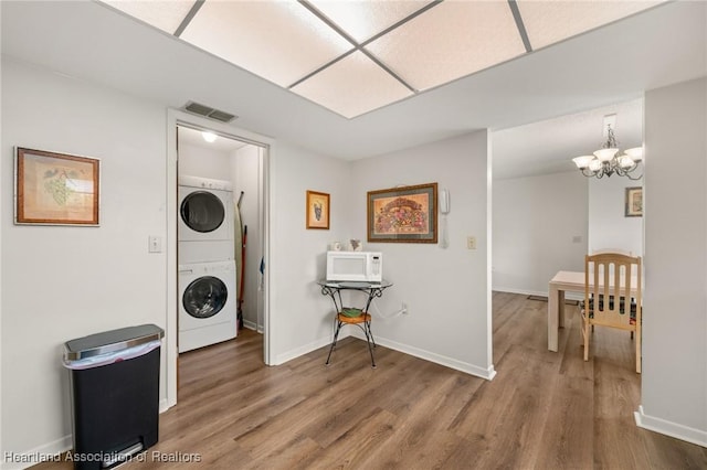 19 A Miracle Ave, Avon Park, FL 33825 - laundry area with stacked washer / drying machine, a chandelier, and wood finished floors