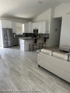 living room featuring lofted ceiling