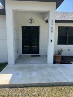doorway to property with roof with shingles