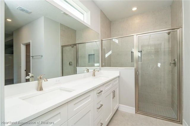 bathroom featuring tile patterned floors, vanity, and a shower with door