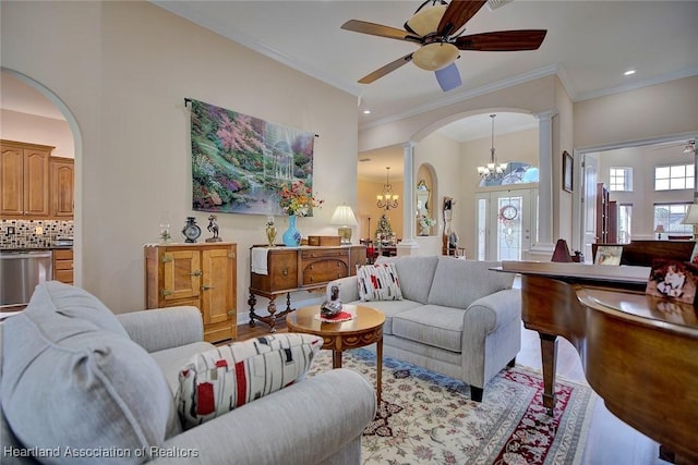 living room featuring ceiling fan with notable chandelier, light hardwood / wood-style floors, decorative columns, and ornamental molding