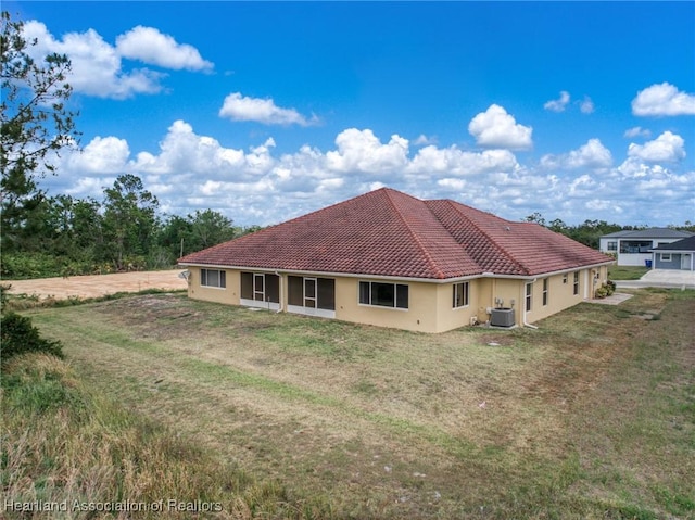 6918 San Benito Dr, Sebring, FL 33872 - rear view of property with stucco siding, central AC, and a lawn