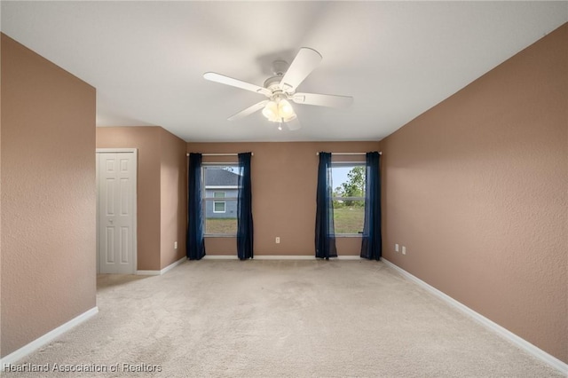 6918 San Benito Dr, Sebring, FL 33872 - unfurnished bedroom with light colored carpet, baseboards, a ceiling fan, and a textured wall