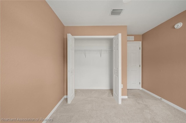 6918 San Benito Dr, Sebring, FL 33872 - unfurnished bedroom featuring light colored carpet, a closet, and baseboards