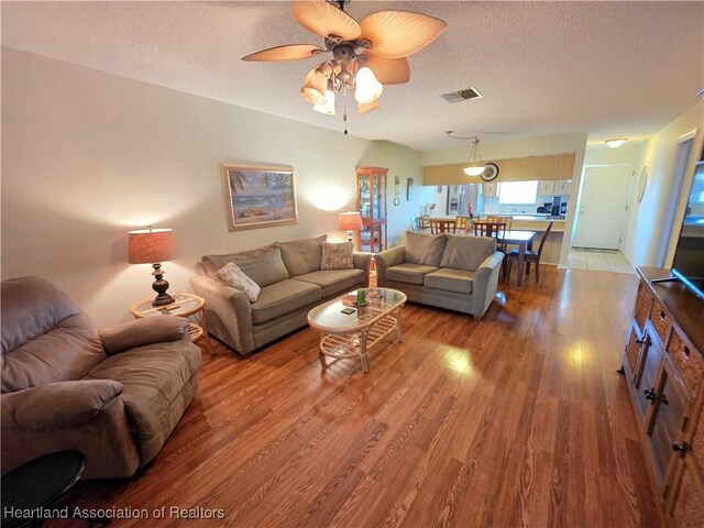 4730 Granada Blvd, Sebring, FL 33872 - living area with light wood-style flooring, a textured ceiling, and a ceiling fan