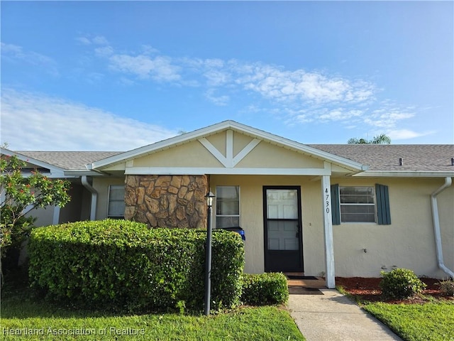 4730 Granada Blvd, Sebring, FL 33872 - view of front of home featuring stucco siding, a shingled roof, and stone siding