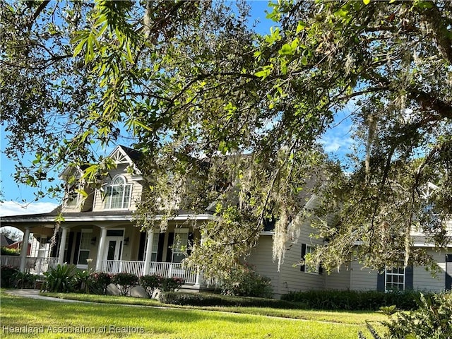 view of front of property with covered porch and a front lawn