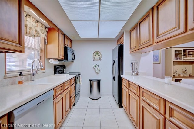 kitchen with sink, light tile patterned floors, and black appliances