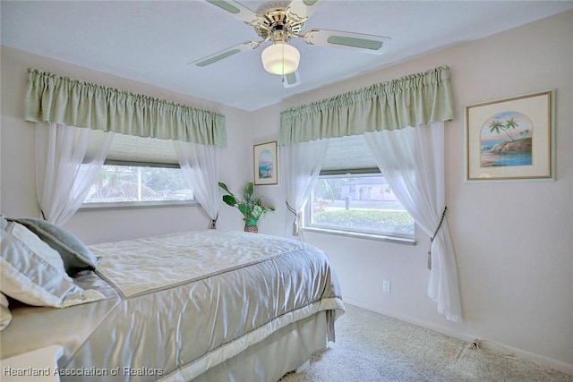 carpeted bedroom with multiple windows and ceiling fan