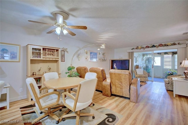 dining area with ceiling fan, a textured ceiling, and light hardwood / wood-style flooring