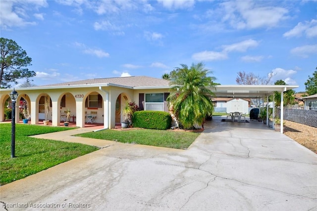 view of front of home with a carport and a front lawn